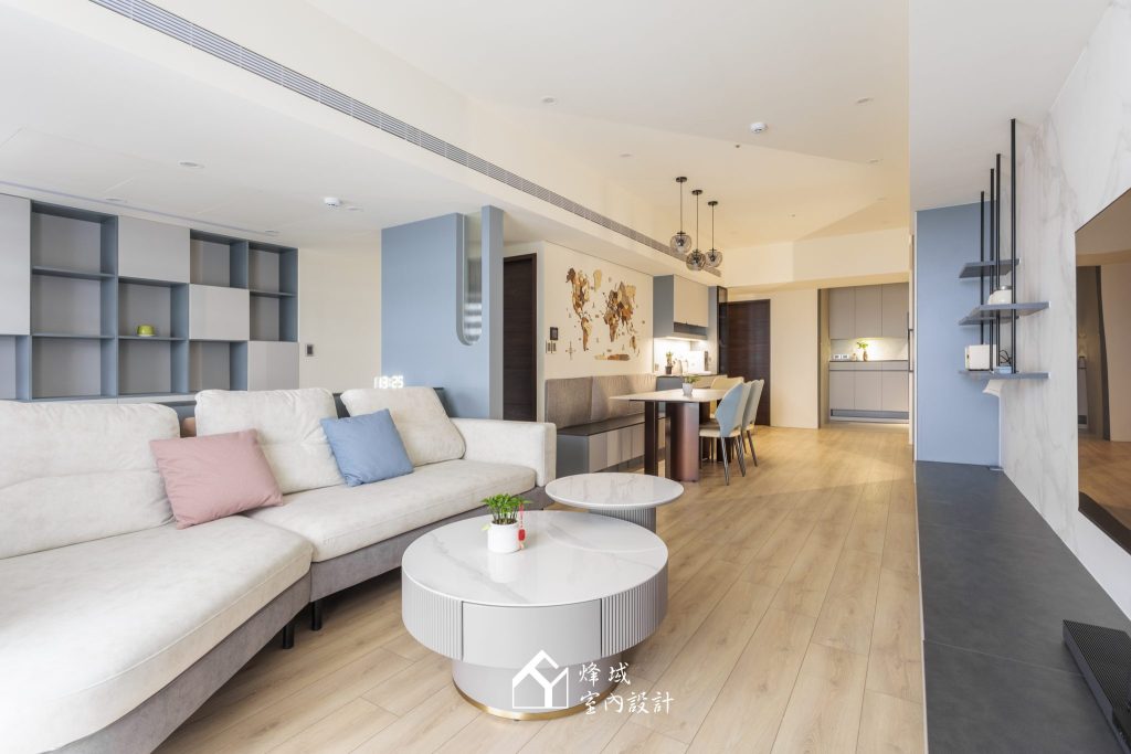 現代莫蘭迪風格客廳，灰藍色跳色牆搭配淺色沙發與木地板，營造舒適居家感。